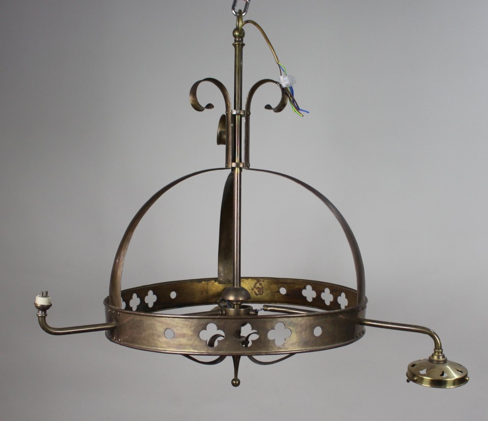 A Victorian Gothic Revival brass three-light gasolier frame featuring an arched cage and pierced trefoil band, presented alongside three ruffled opalescent glass shades. View VI