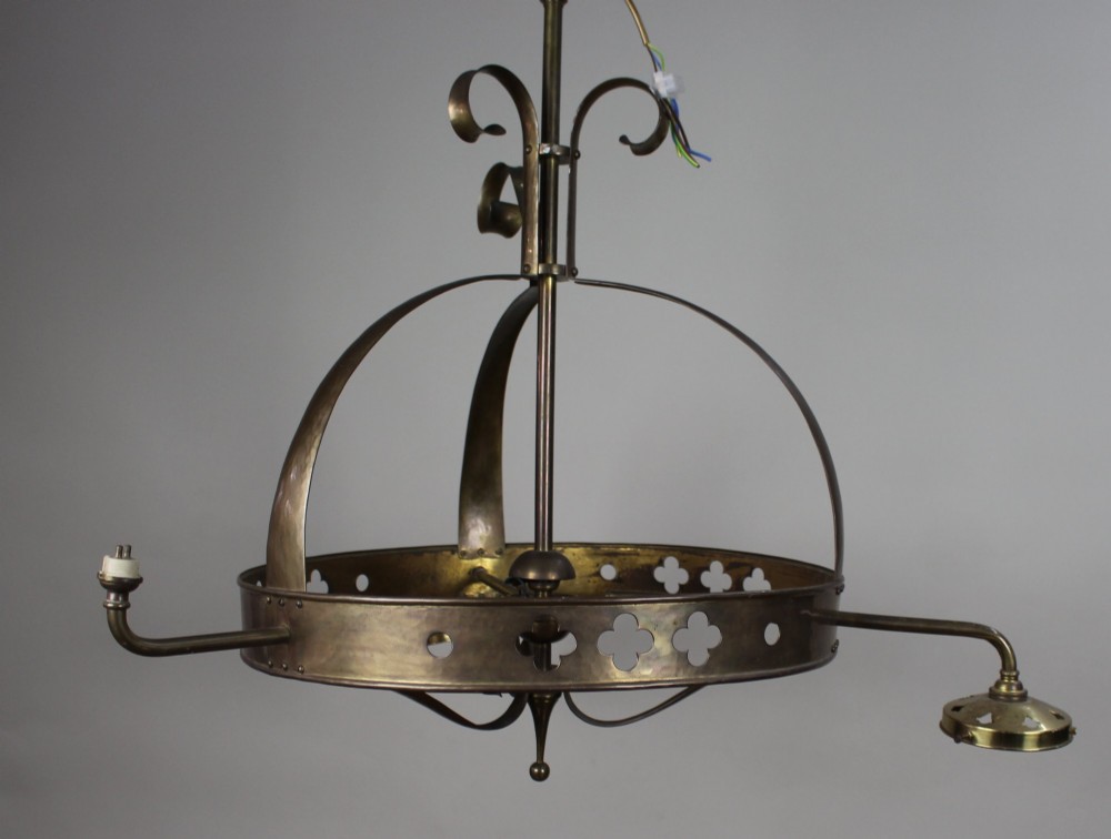 A Victorian Gothic Revival brass three-light gasolier frame featuring an arched cage and pierced trefoil band, presented alongside three ruffled opalescent glass shades. View VII