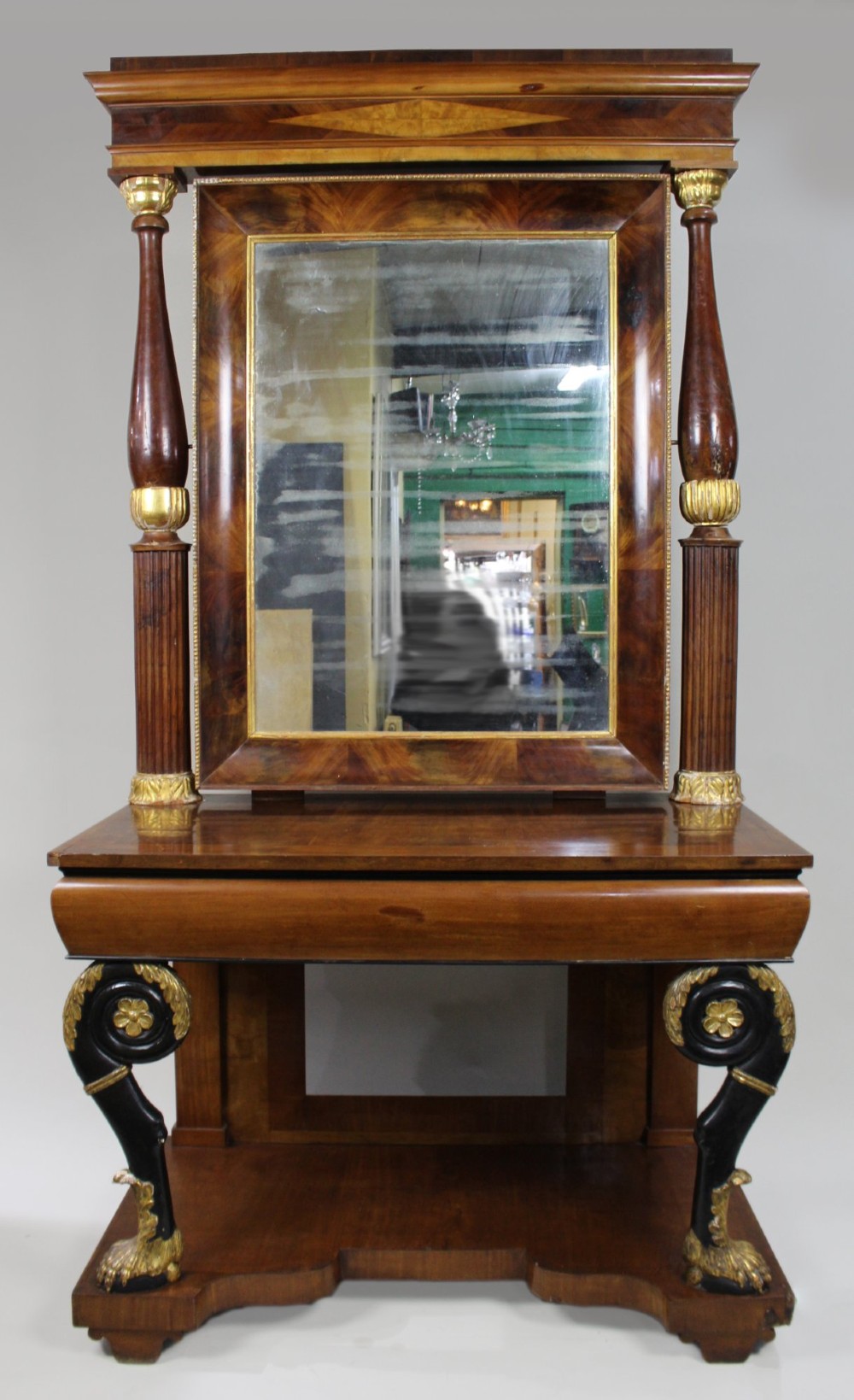 An antique mahogany pier console table featuring carved parcel gilt columns, ebonised monopodia legs with paw feet, and an integrated rectangular pier mirror.