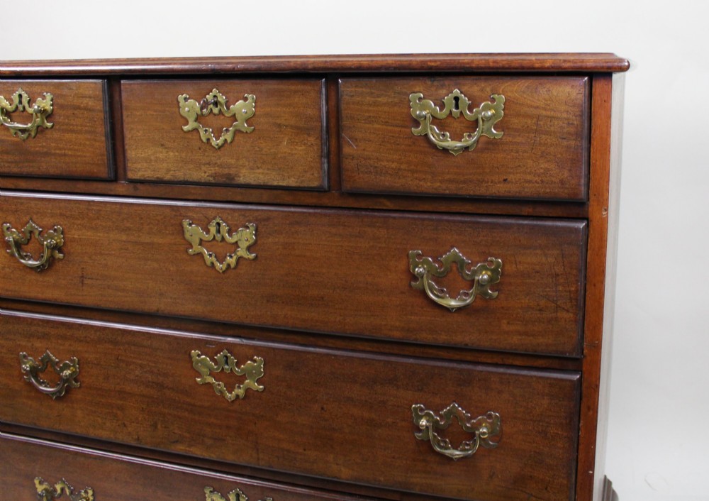 An 18th-century George III mahogany chest of drawers featuring three small upper drawers over three long drawers, fitted with brass handles and supported on bracket feet. View V