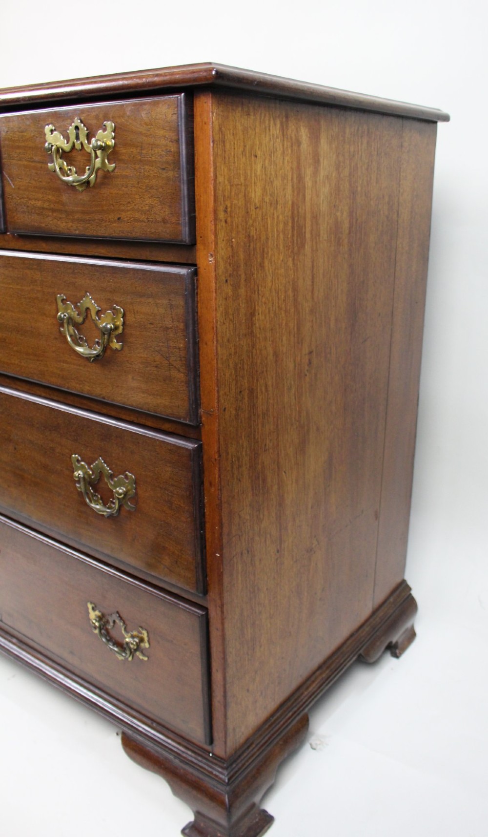 An 18th-century George III mahogany chest of drawers featuring three small upper drawers over three long drawers, fitted with brass handles and supported on bracket feet. View VII