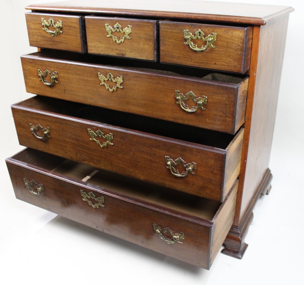 An 18th-century George III mahogany chest of drawers featuring three small upper drawers over three long drawers, fitted with brass handles and supported on bracket feet. View X