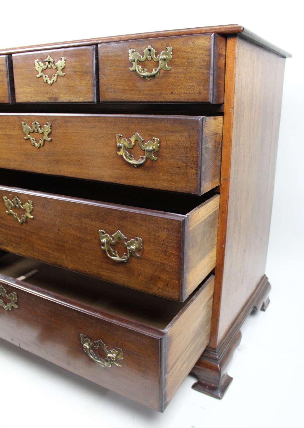 An 18th-century George III mahogany chest of drawers featuring three small upper drawers over three long drawers, fitted with brass handles and supported on bracket feet. View XII