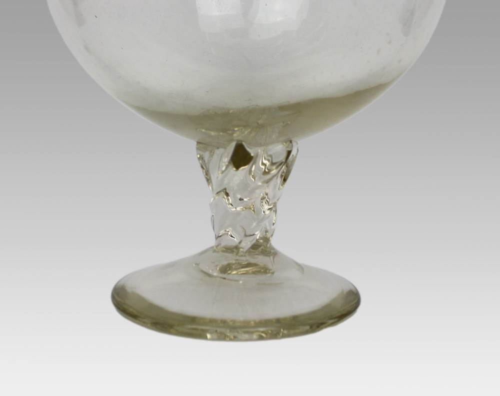 A late 19th-century Italian hand-blown clear glass footed ewer featuring a spherical body, pinched spout, applied ribbed handle, and twisted stem on a flat circular base. View V