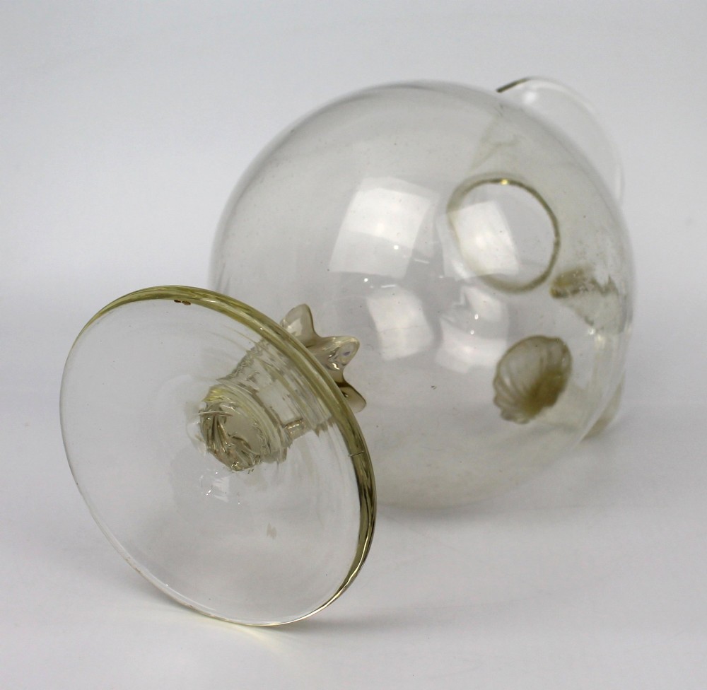 A late 19th-century Italian hand-blown clear glass footed ewer featuring a spherical body, pinched spout, applied ribbed handle, and twisted stem on a flat circular base. View VI