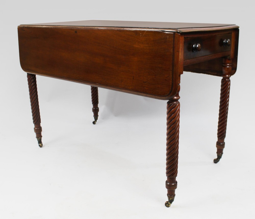 A Victorian mahogany Pembroke table with two hinged drop leaves, a single end drawer with turned wood knobs, spiral-twisted legs, and brass castors.
