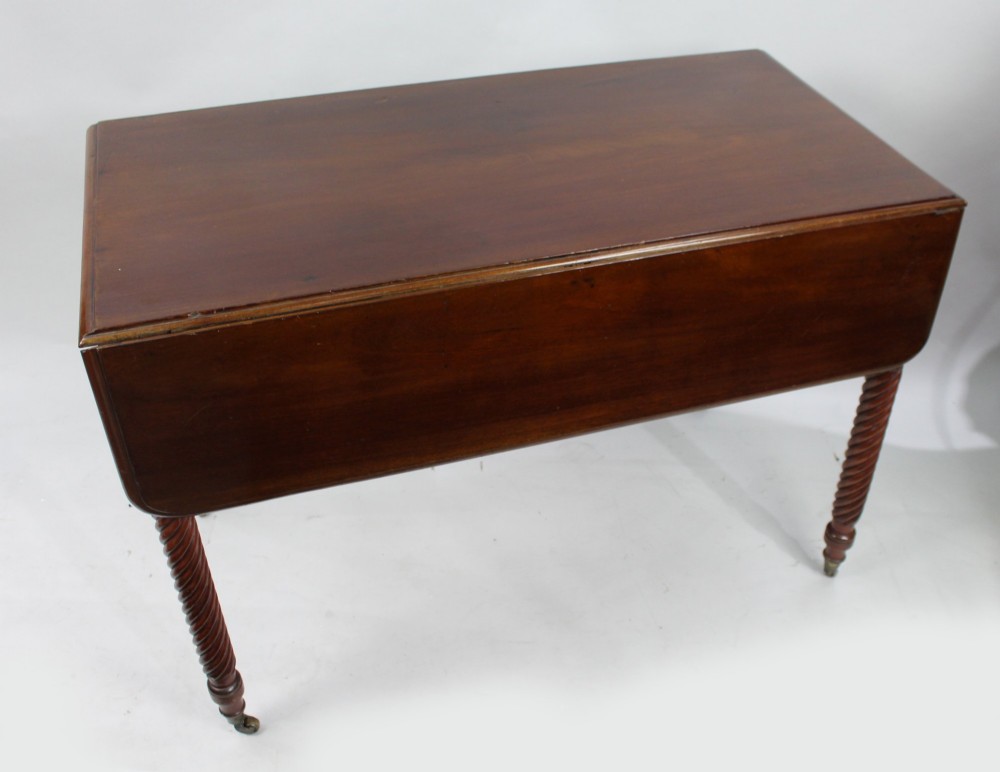 A Victorian mahogany Pembroke table with two hinged drop leaves, a single end drawer with turned wood knobs, spiral-twisted legs, and brass castors. View II