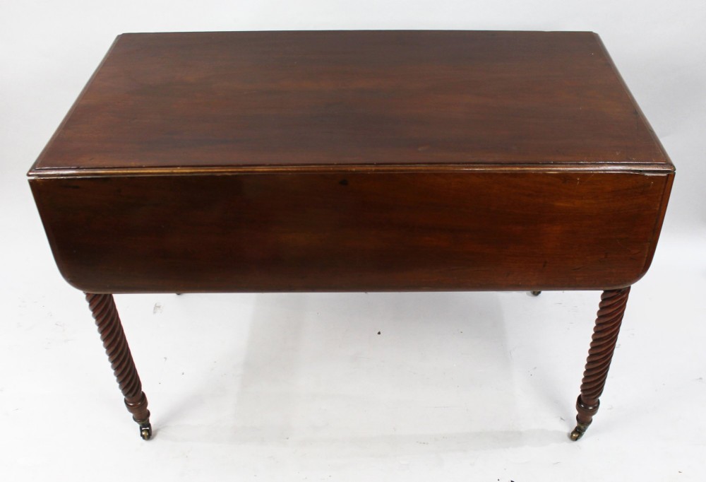 A Victorian mahogany Pembroke table with two hinged drop leaves, a single end drawer with turned wood knobs, spiral-twisted legs, and brass castors. View VI