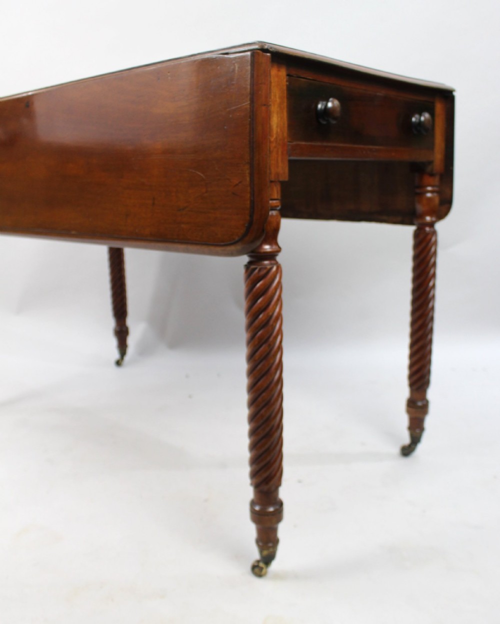 A Victorian mahogany Pembroke table with two hinged drop leaves, a single end drawer with turned wood knobs, spiral-twisted legs, and brass castors. View VIII