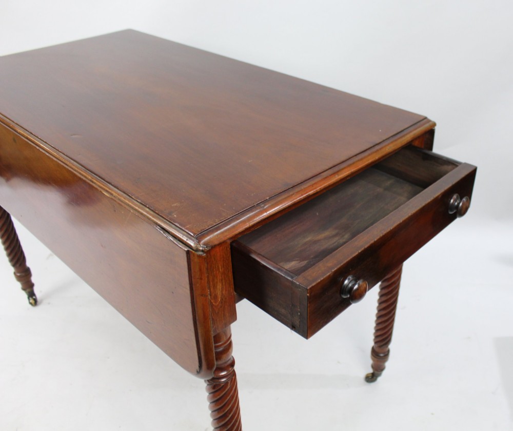 A Victorian mahogany Pembroke table with two hinged drop leaves, a single end drawer with turned wood knobs, spiral-twisted legs, and brass castors. View IX