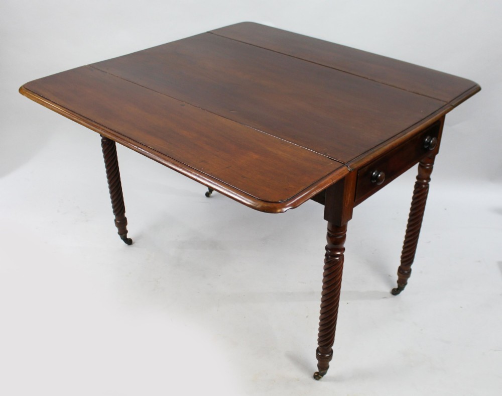 A Victorian mahogany Pembroke table with two hinged drop leaves, a single end drawer with turned wood knobs, spiral-twisted legs, and brass castors. View X