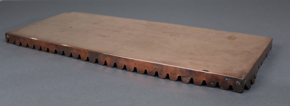 A rectangular Georgian copper hearth plate featuring a scalloped lower edge and a polished metallic surface. View III
