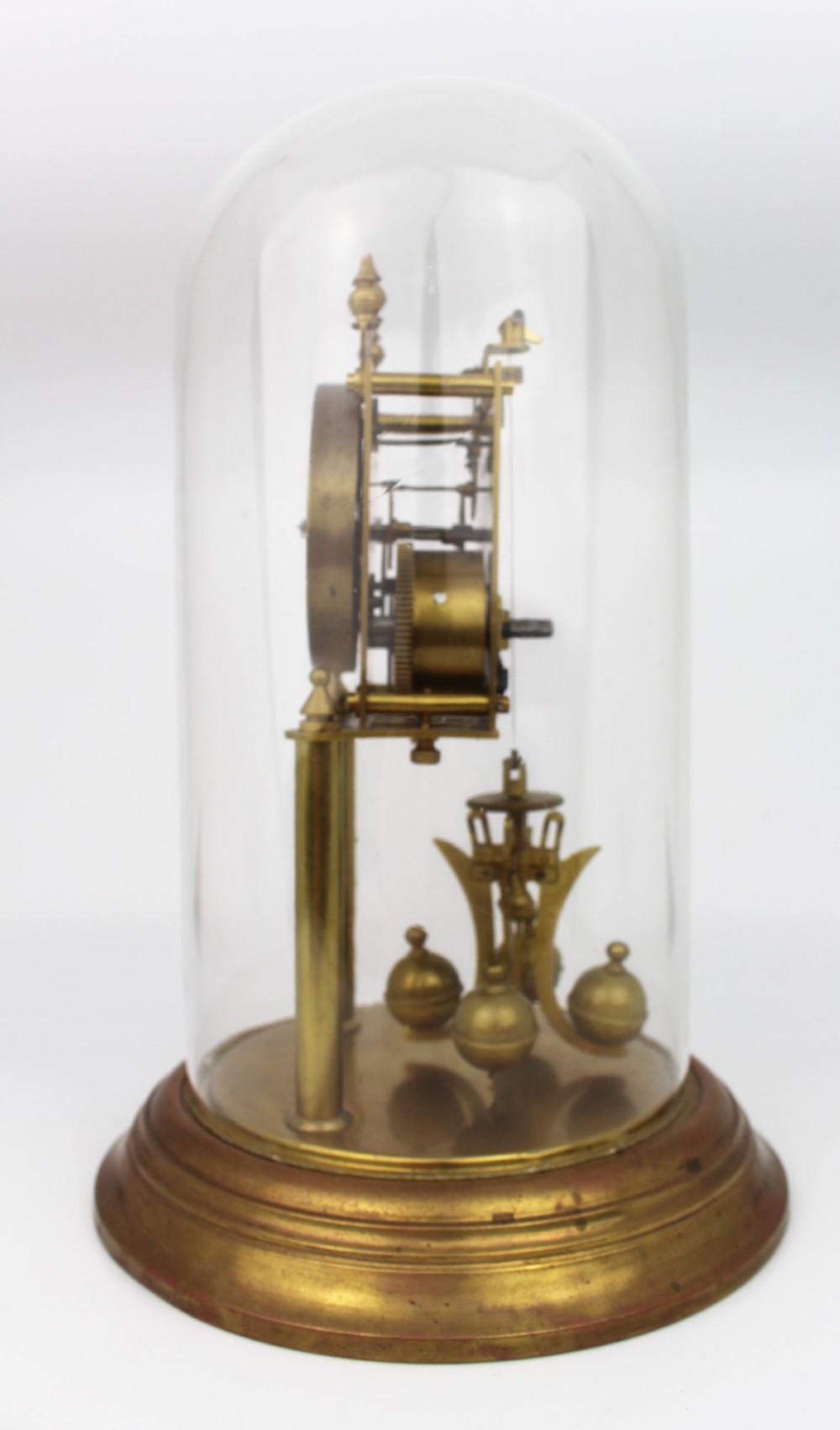 An antique German anniversary clock featuring a brass movement and four-ball rotary pendulum enclosed under a clear glass dome. View II