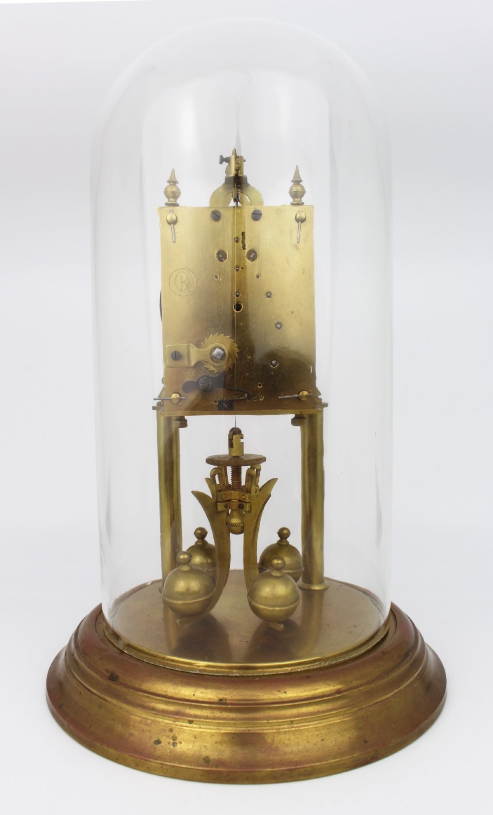 An antique German anniversary clock featuring a brass movement and four-ball rotary pendulum enclosed under a clear glass dome. View III
