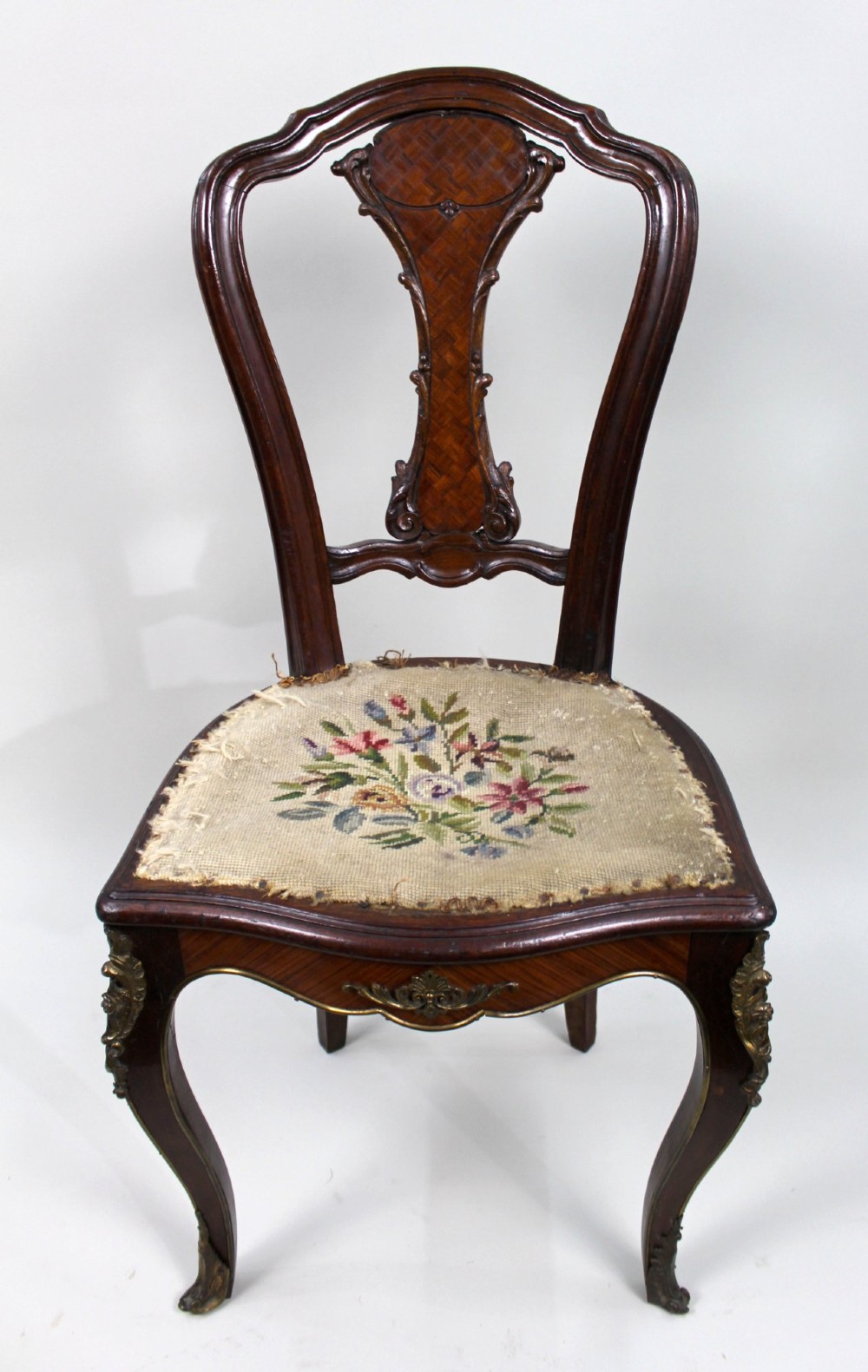 An antique French side chair featuring a kingwood back frame with a parquetry splat, cabriole front legs decorated with ormolu mounts, and a floral needlepoint seat. View IV