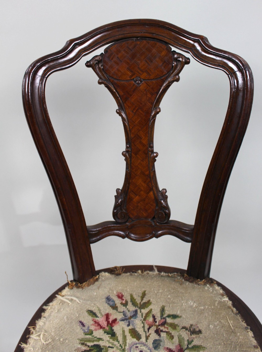 An antique French side chair featuring a kingwood back frame with a parquetry splat, cabriole front legs decorated with ormolu mounts, and a floral needlepoint seat. View V