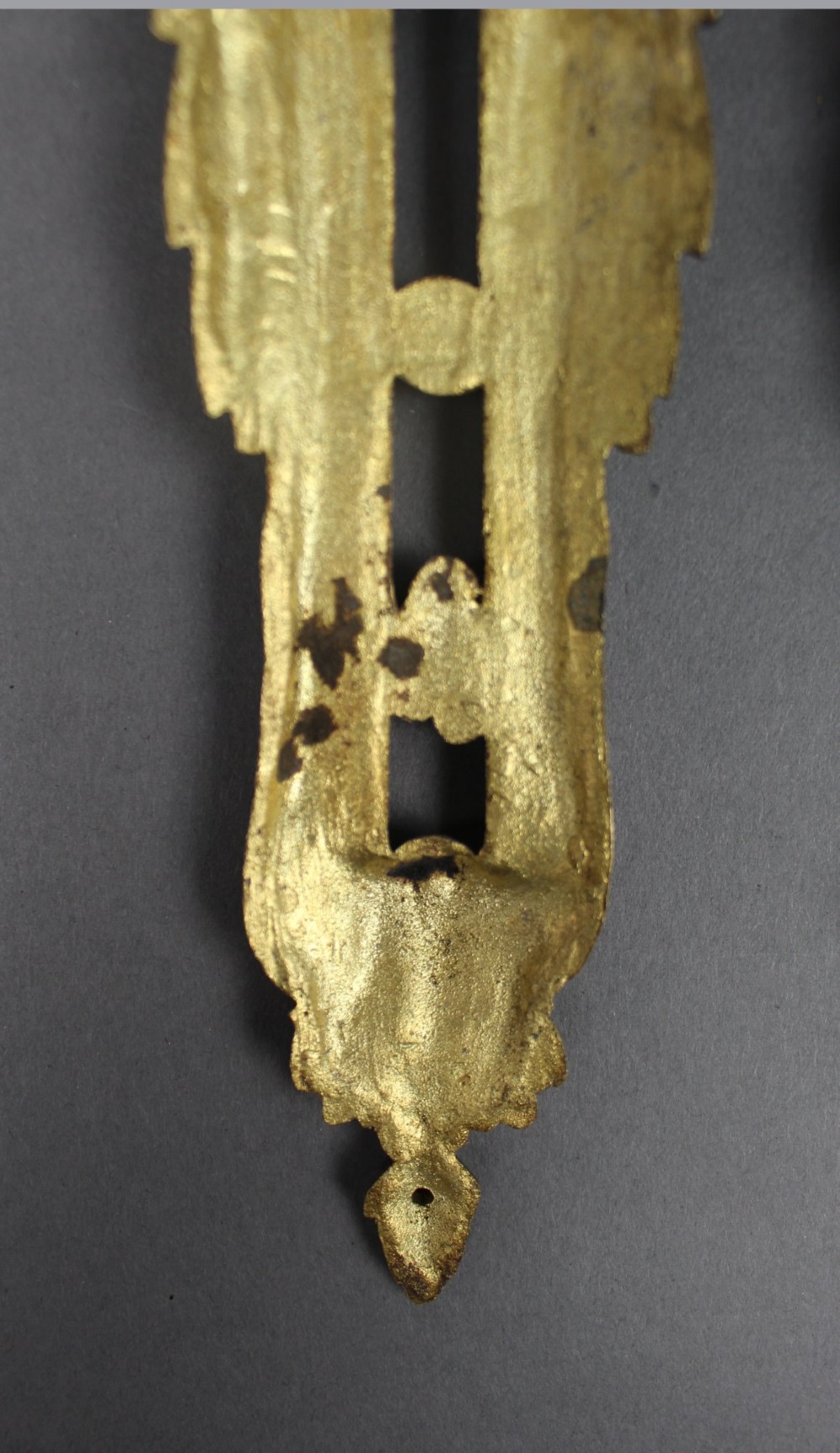 A pair of ornate gilt bronze furniture mounts featuring acanthus leaf scrollwork and symmetrical pierced design in the Louis XVI style. View VII