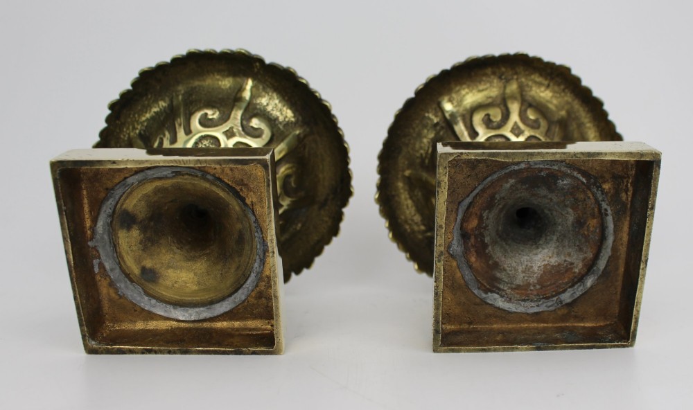 A pair of small antique bronze and brass urns featuring scalloped rims, relief scrollwork, and flared pedestals on square bases. View XIII