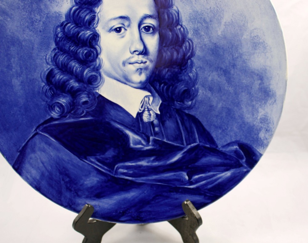 A circular glazed ceramic charger featuring a monochrome cobalt blue hand-painted portrait of a seventeenth-century man against a light blue background. View VI