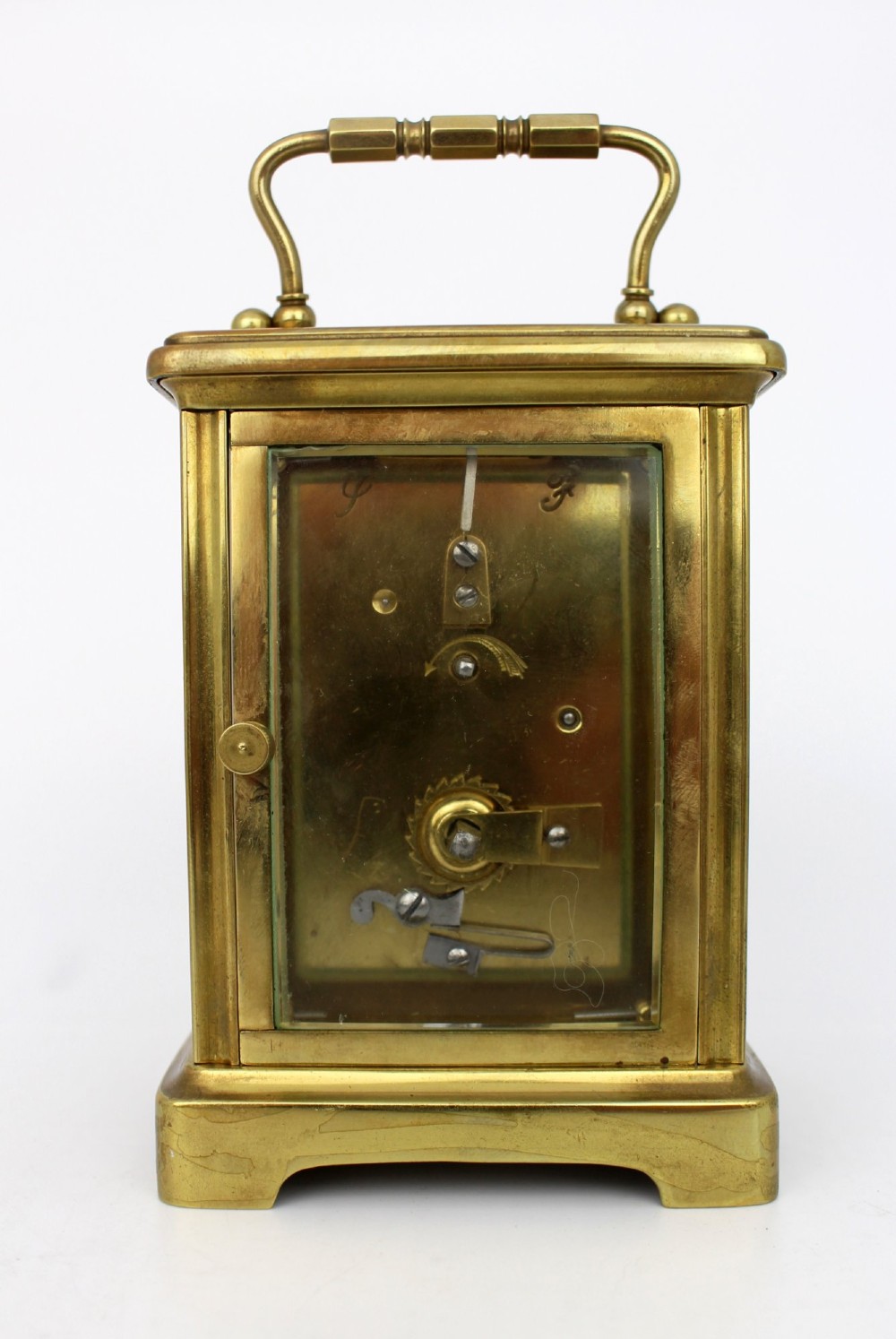 An antique brass carriage clock featuring rectangular glass side panels, a white enamel dial with black Roman numerals, and a folding top handle. View III
