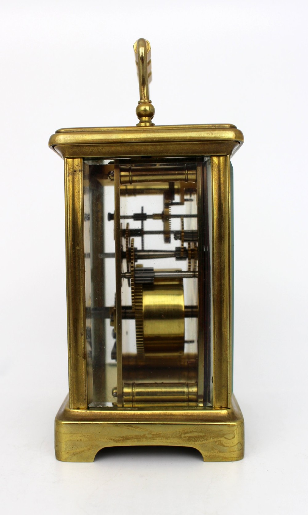 An antique brass carriage clock featuring rectangular glass side panels, a white enamel dial with black Roman numerals, and a folding top handle. View VIII