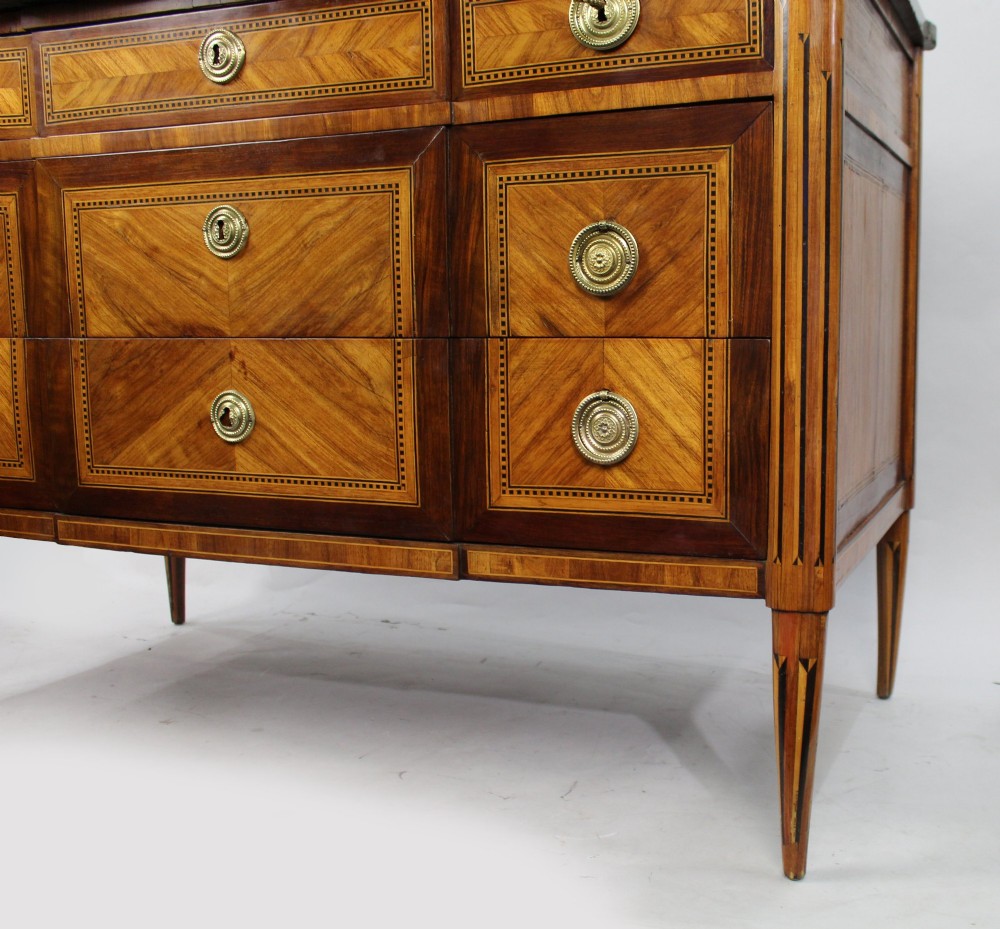 An 18th-century French Louis XVI commode featuring geometric parquetry wood inlay, tapered legs, brass ring handles, and a grey marble top. View VII
