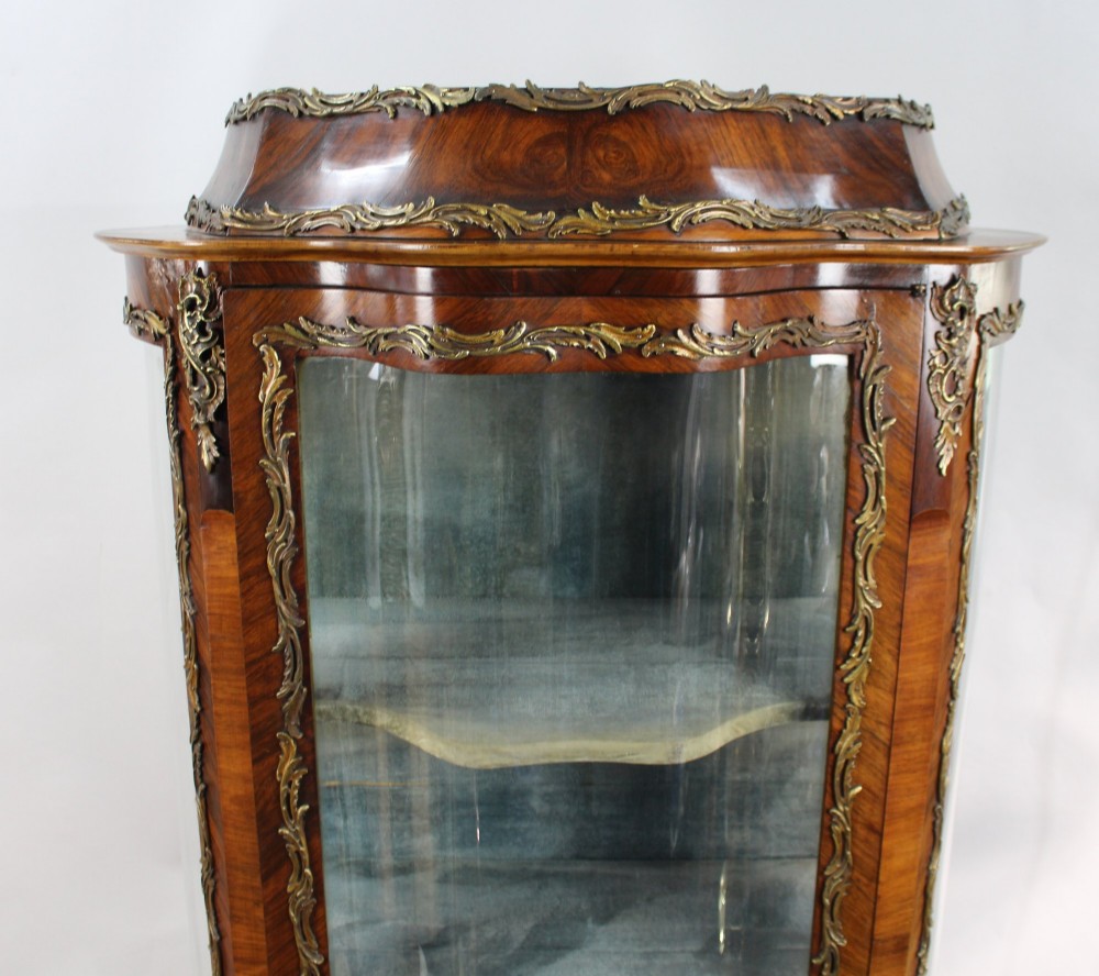 A nineteenth-century French serpentine display cabinet featuring curved glass panels, gilt bronze mounts, and hand-painted Vernis Martin panels on the lower section. View III
