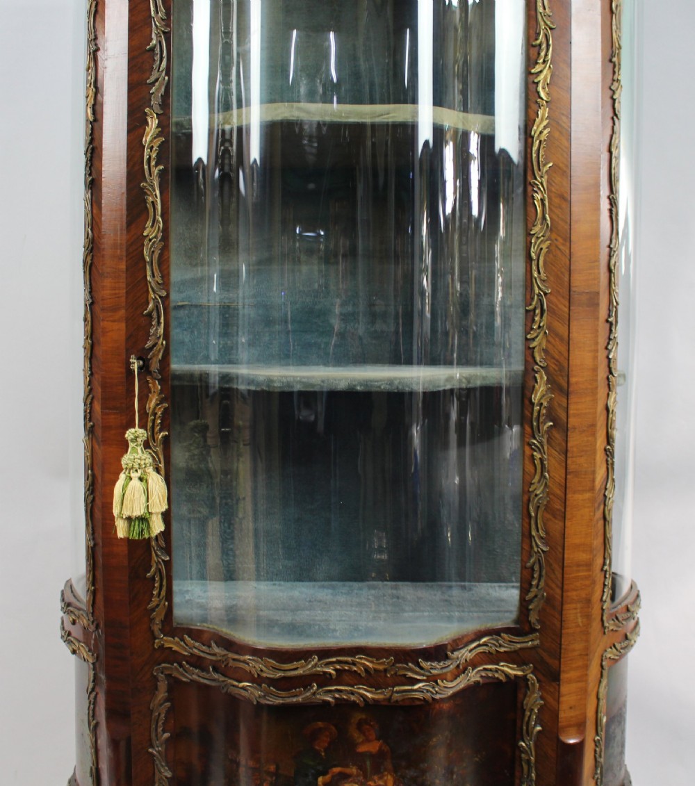 A nineteenth-century French serpentine display cabinet featuring curved glass panels, gilt bronze mounts, and hand-painted Vernis Martin panels on the lower section. View IV