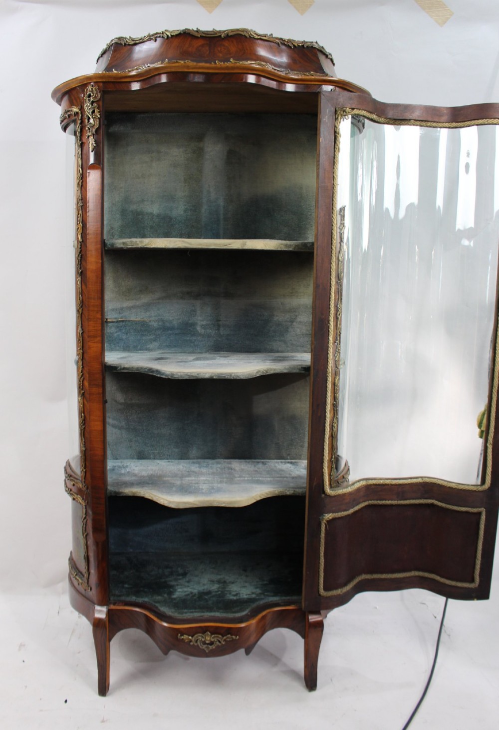 A nineteenth-century French serpentine display cabinet featuring curved glass panels, gilt bronze mounts, and hand-painted Vernis Martin panels on the lower section. View VII