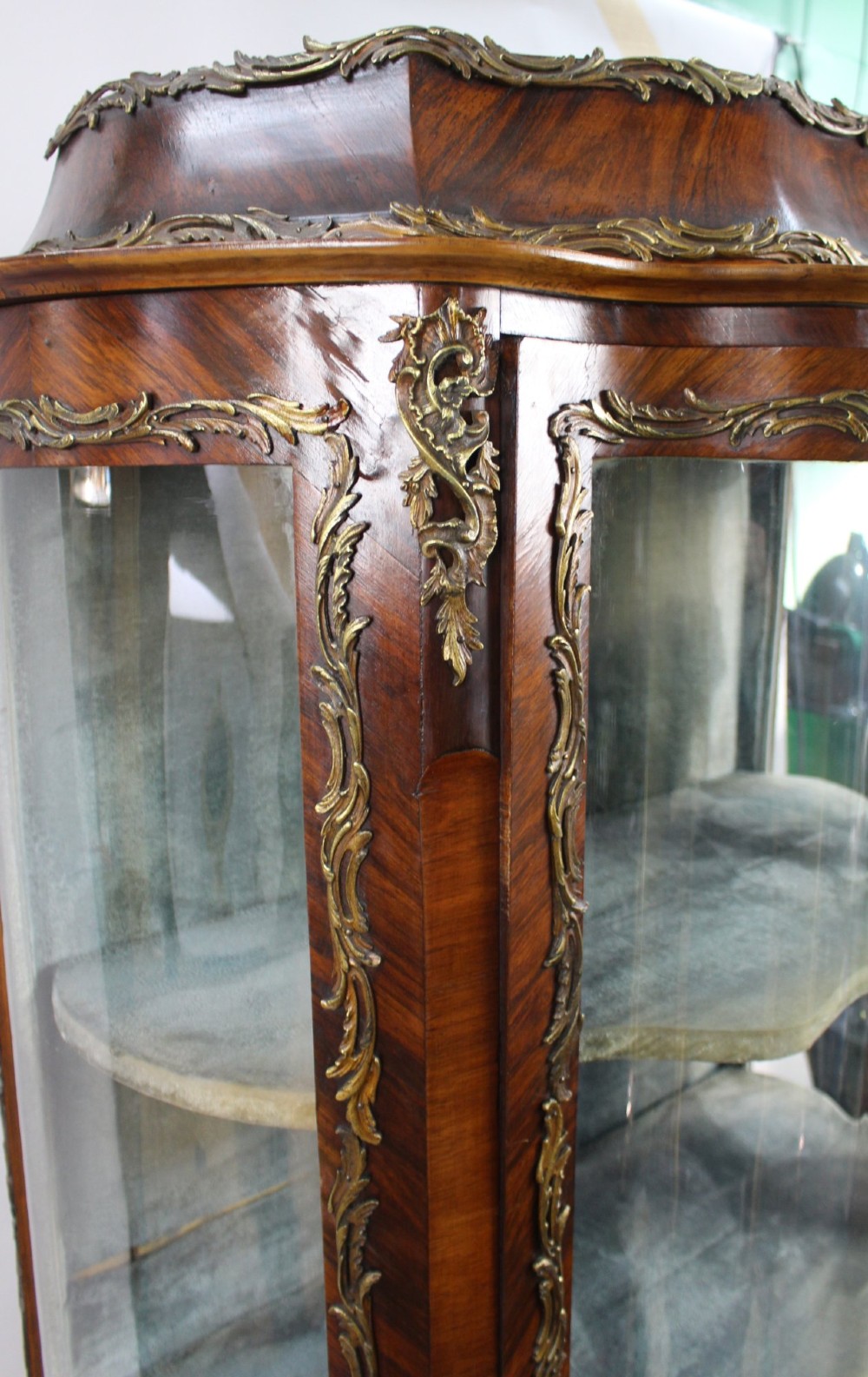 A nineteenth-century French serpentine display cabinet featuring curved glass panels, gilt bronze mounts, and hand-painted Vernis Martin panels on the lower section. View VIII