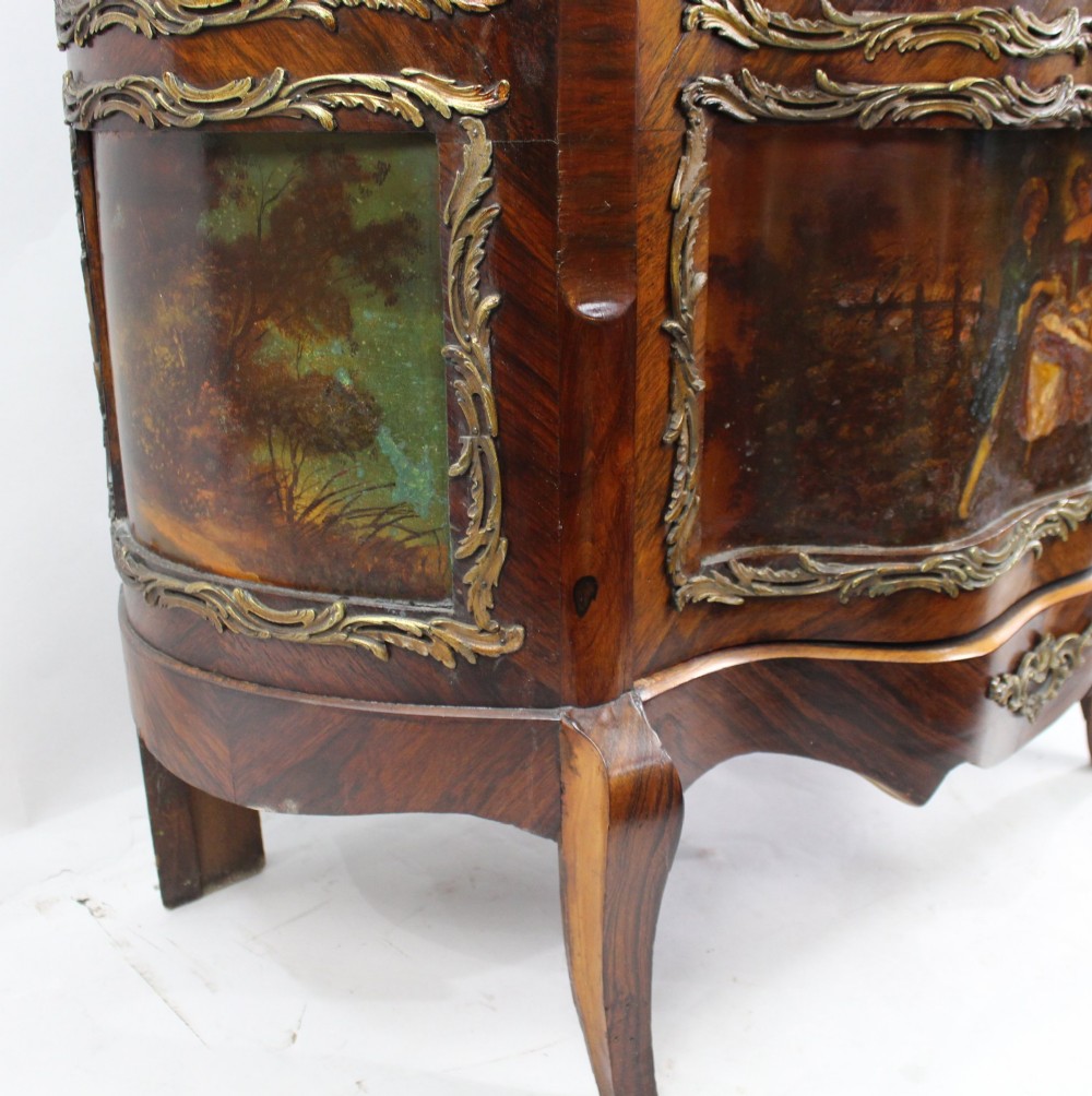 A nineteenth-century French serpentine display cabinet featuring curved glass panels, gilt bronze mounts, and hand-painted Vernis Martin panels on the lower section. View IX