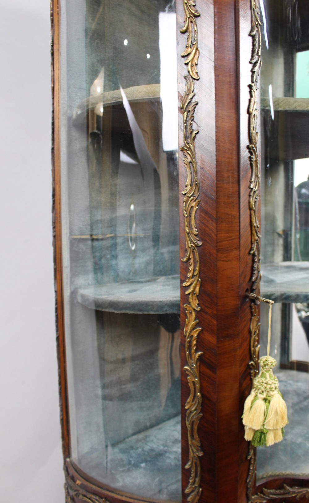 A nineteenth-century French serpentine display cabinet featuring curved glass panels, gilt bronze mounts, and hand-painted Vernis Martin panels on the lower section. View X