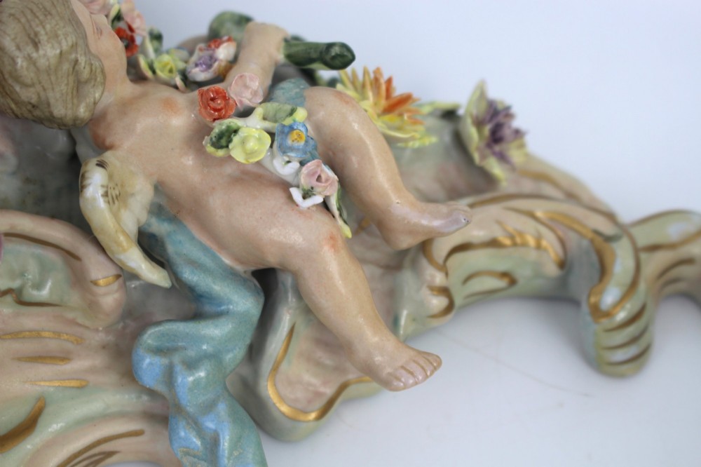 A pair of Rococo Revival porcelain wall corbels decorated with sculpted cherubs, elaborate scrollwork, and colourful encrusted flowers with gilt accents. View XIII