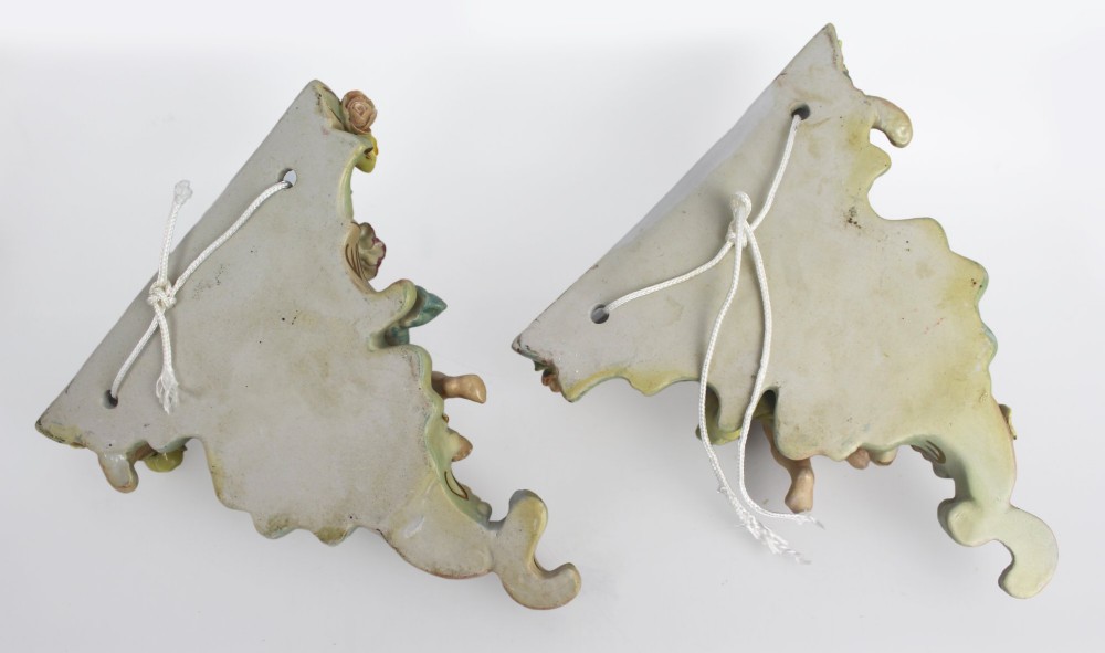 A pair of Rococo Revival porcelain wall corbels decorated with sculpted cherubs, elaborate scrollwork, and colourful encrusted flowers with gilt accents. View XIV