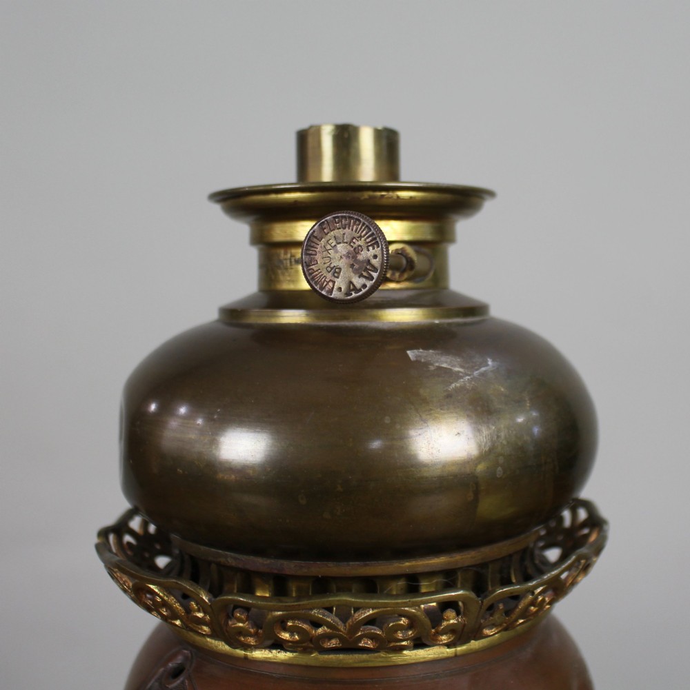 A Meiji period Japanese dark brown bronze oil lamp featuring reticulated openwork, a gilded dragon roundel, brass burner fittings, and decorative scroll feet. View II