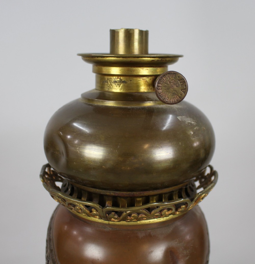 A Meiji period Japanese dark brown bronze oil lamp featuring reticulated openwork, a gilded dragon roundel, brass burner fittings, and decorative scroll feet. View XI
