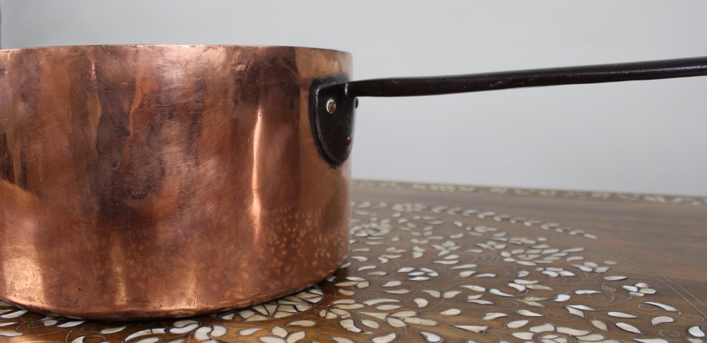 A large antique Georgian copper saucepan featuring a straight cylindrical body and a long wrought iron handle fastened with metal rivets. View III