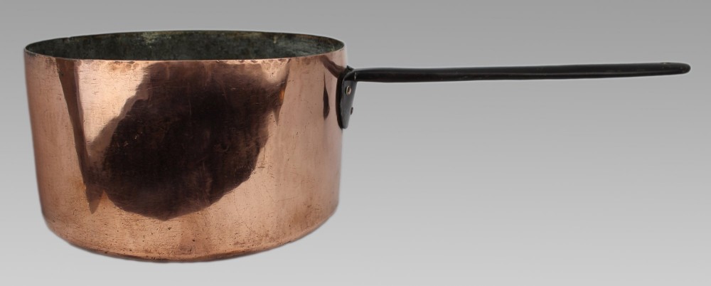 A large antique Georgian copper saucepan featuring a straight cylindrical body and a long wrought iron handle fastened with metal rivets. View VI