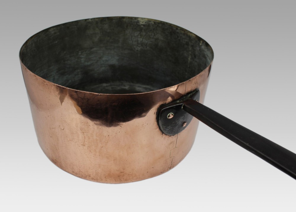 A large antique Georgian copper saucepan featuring a straight cylindrical body and a long wrought iron handle fastened with metal rivets. View IX
