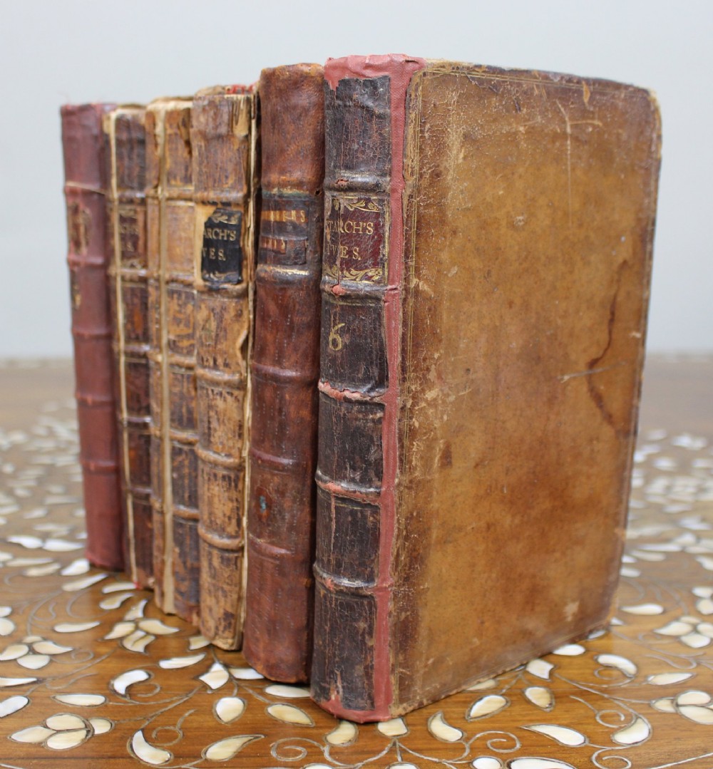 A six-volume set of eighteenth-century leather-bound books with distressed brown spines and gilt lettering standing upright. View IV