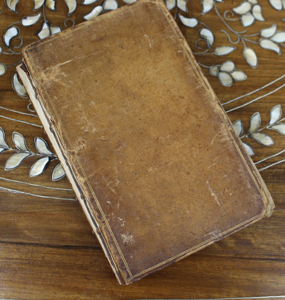 A six-volume set of eighteenth-century leather-bound books with distressed brown spines and gilt lettering standing upright. View XIV