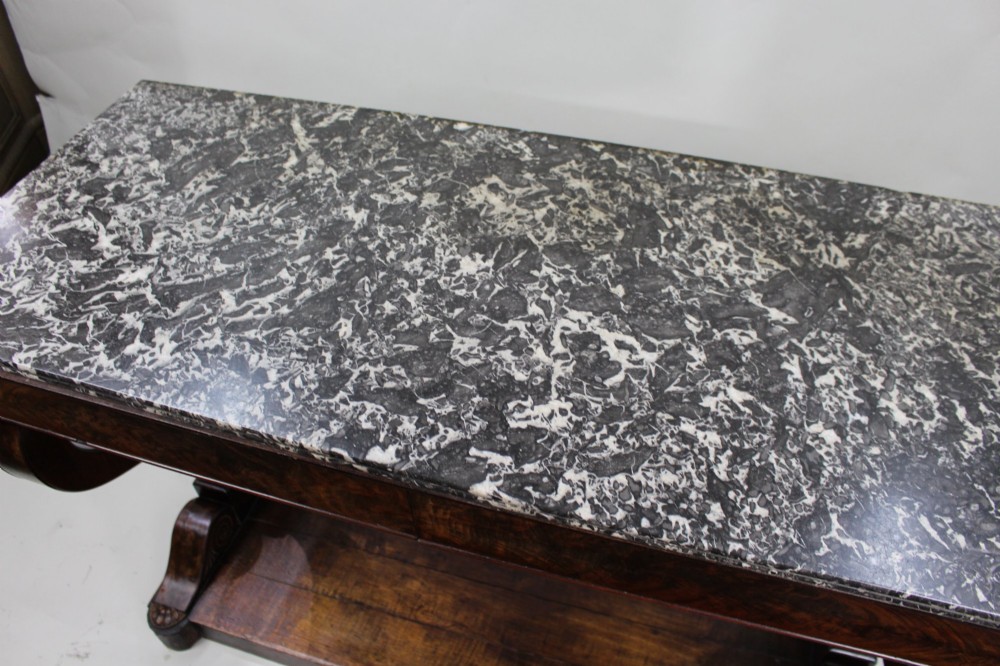 An antique dark mahogany French console table featuring a grey and white mottled marble top, curved scroll legs, and a low plinth shelf. View VII
