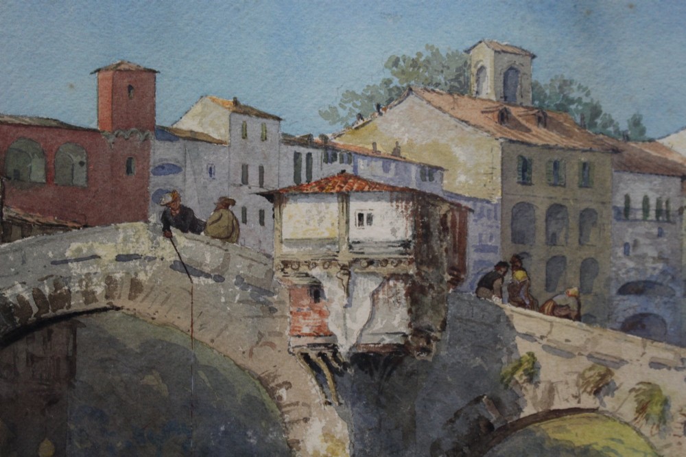 A 19th-century framed watercolour painting depicting an Italian townscape with a stone arch bridge crossing a river beneath a pale blue sky. View II