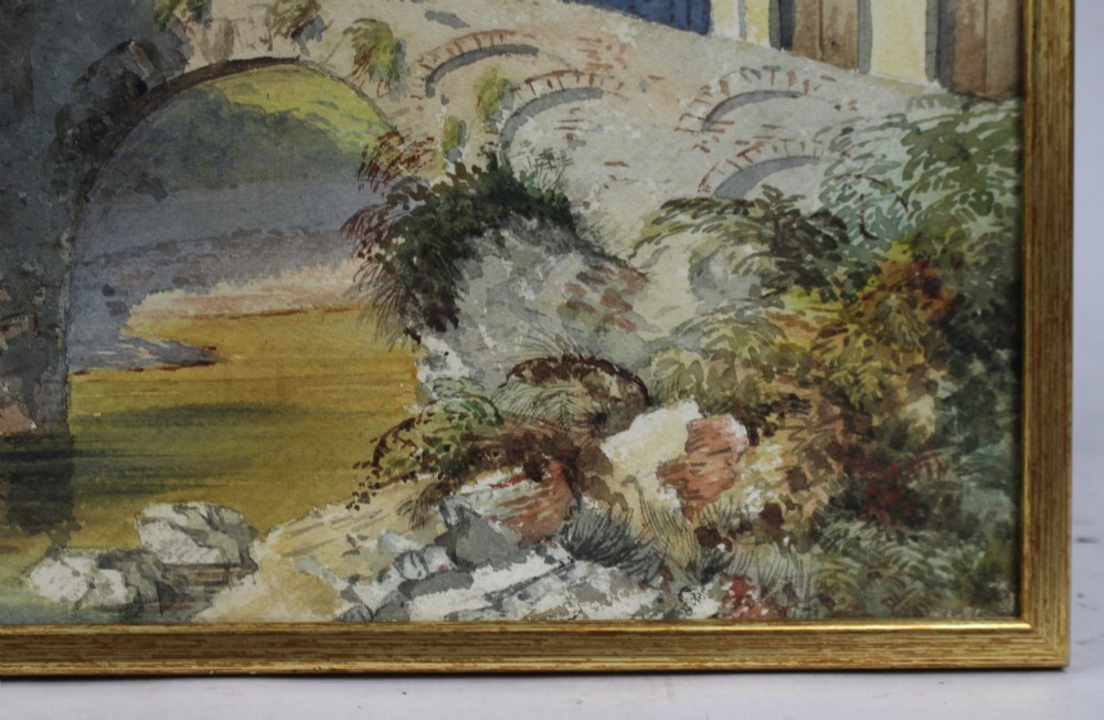 A 19th-century framed watercolour painting depicting an Italian townscape with a stone arch bridge crossing a river beneath a pale blue sky. View IV