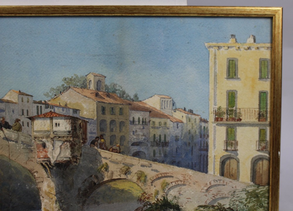 A 19th-century framed watercolour painting depicting an Italian townscape with a stone arch bridge crossing a river beneath a pale blue sky. View V