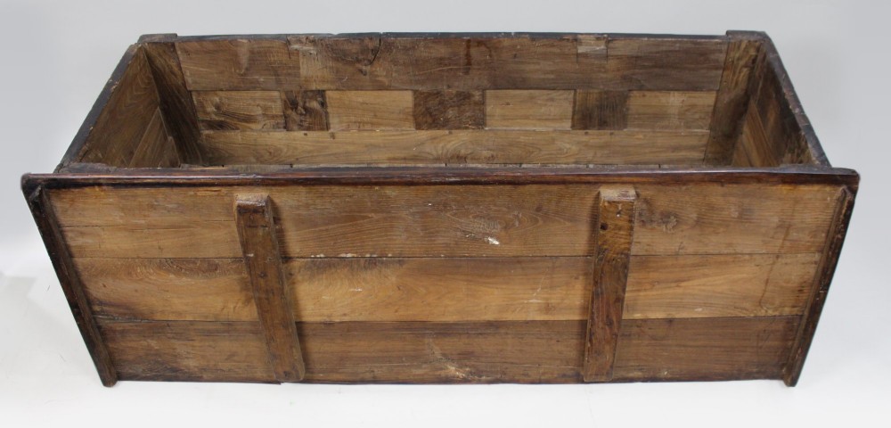 A low rectangular dark oak coffer with a plank lid and four carved recessed panels accented with brass studs. View XI
