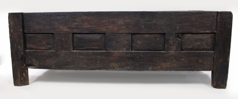 A low rectangular dark oak coffer with a plank lid and four carved recessed panels accented with brass studs. View XV