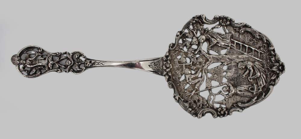An antique Flemish silver spoon featuring an intricately pierced bowl decorated with a figurative orchard scene and a scrolling openwork handle. View II
