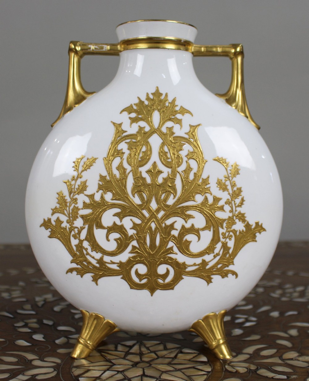 A white porcelain moon flask vase with twin gilded handles, four scroll feet, and a hand-painted portrait of a woman in a purple hat signed Baston. View VI