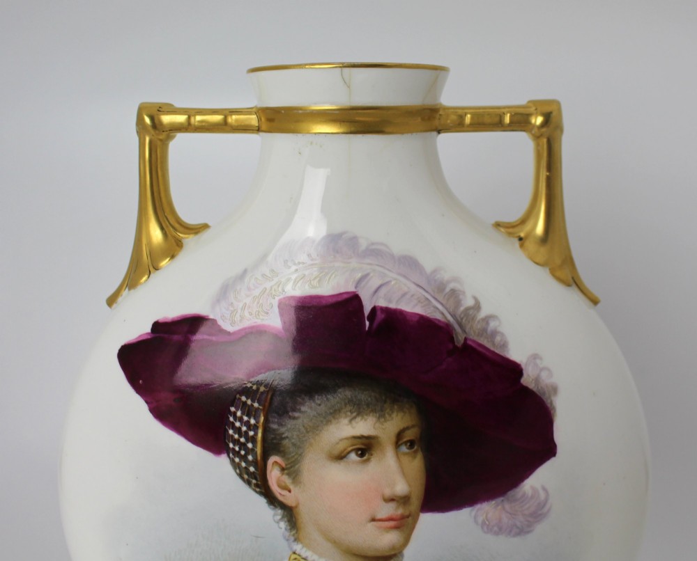 A white porcelain moon flask vase with twin gilded handles, four scroll feet, and a hand-painted portrait of a woman in a purple hat signed Baston. View IX